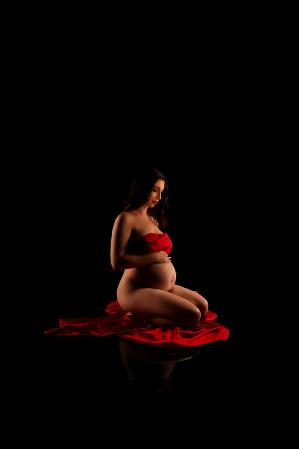 Pregnant individual posing for Nuovo’s Life collection on a black backdrop