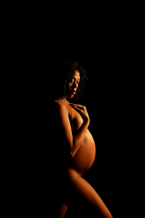Pregnant individual posing for Nuovo’s Life collection on a black backdrop