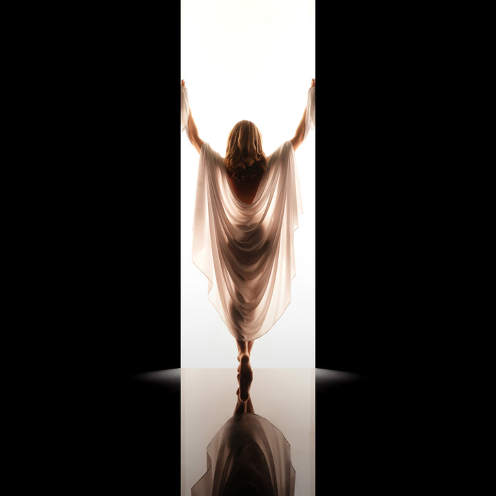 Woman draped in flowing cream fabric poses from behind in a backlit studio doorway for an elegant fine art boudoir portrait.