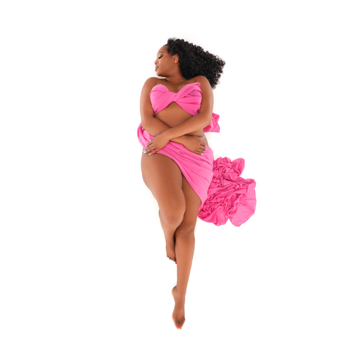 High key fine art portrait of a woman in pink chiffon photographed from above on a white backdrop